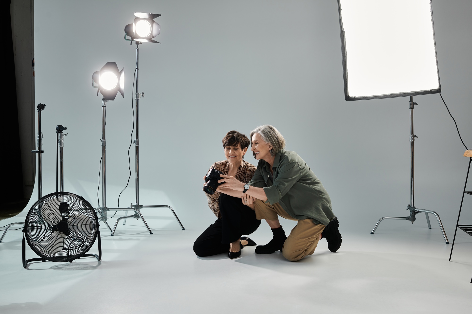 Capturing love: middle aged lesbian couple kneeling for the shot