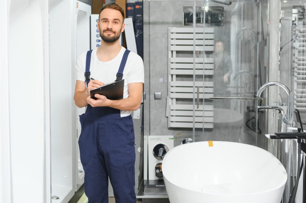 Plumber in uniform at showcase in plumbering store